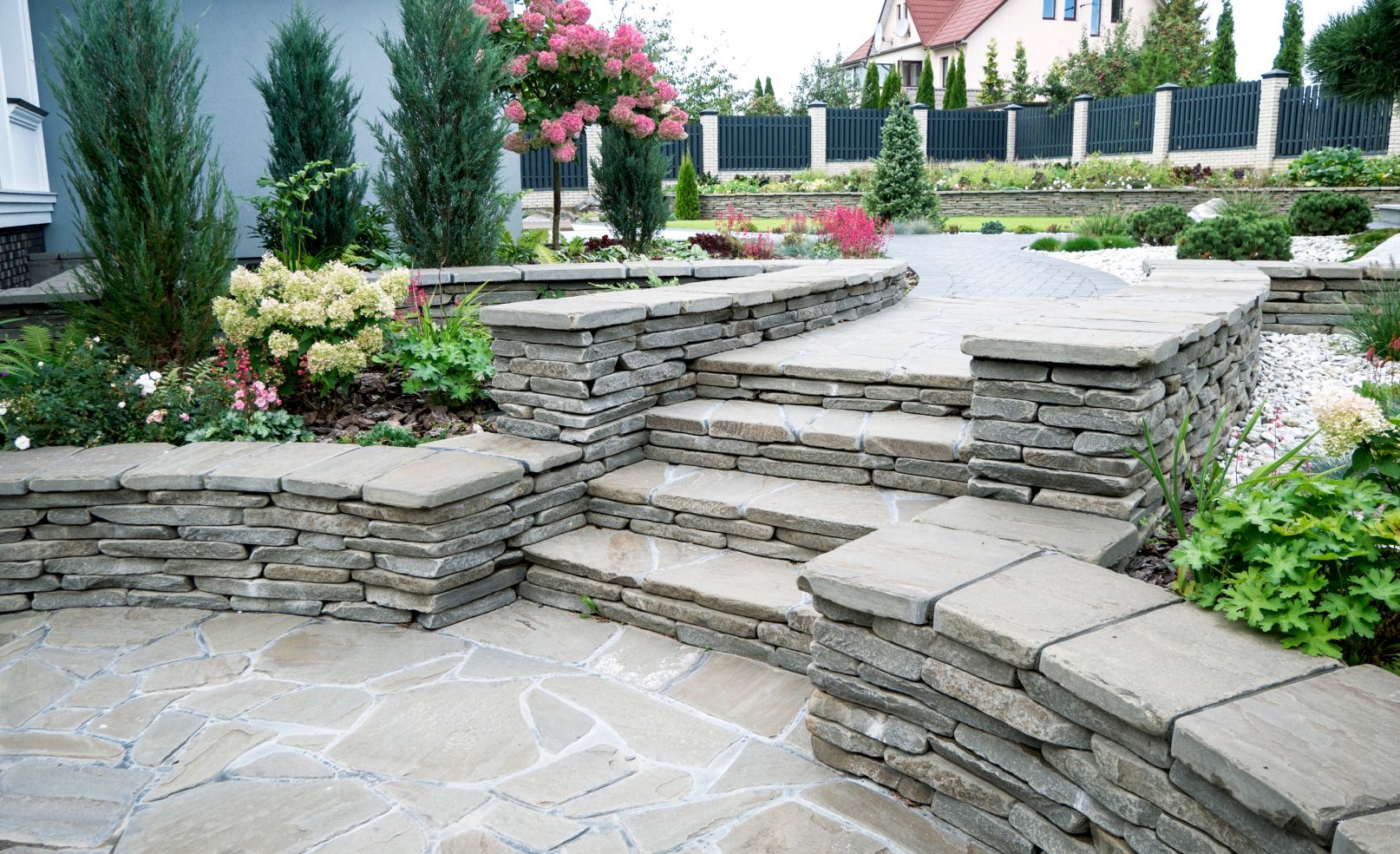 Gartenweg mit kleiner Treppe aus grauen Steinen